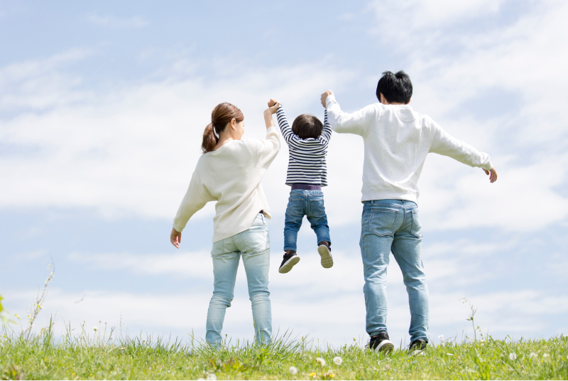家族3人が手を繋いでいる後ろ姿の写真