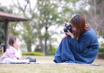 親がカメラで子どもを撮っている写真
