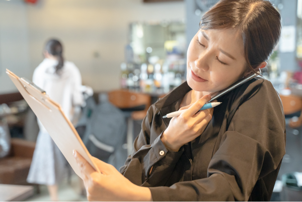 女性が電話しながら仕事している